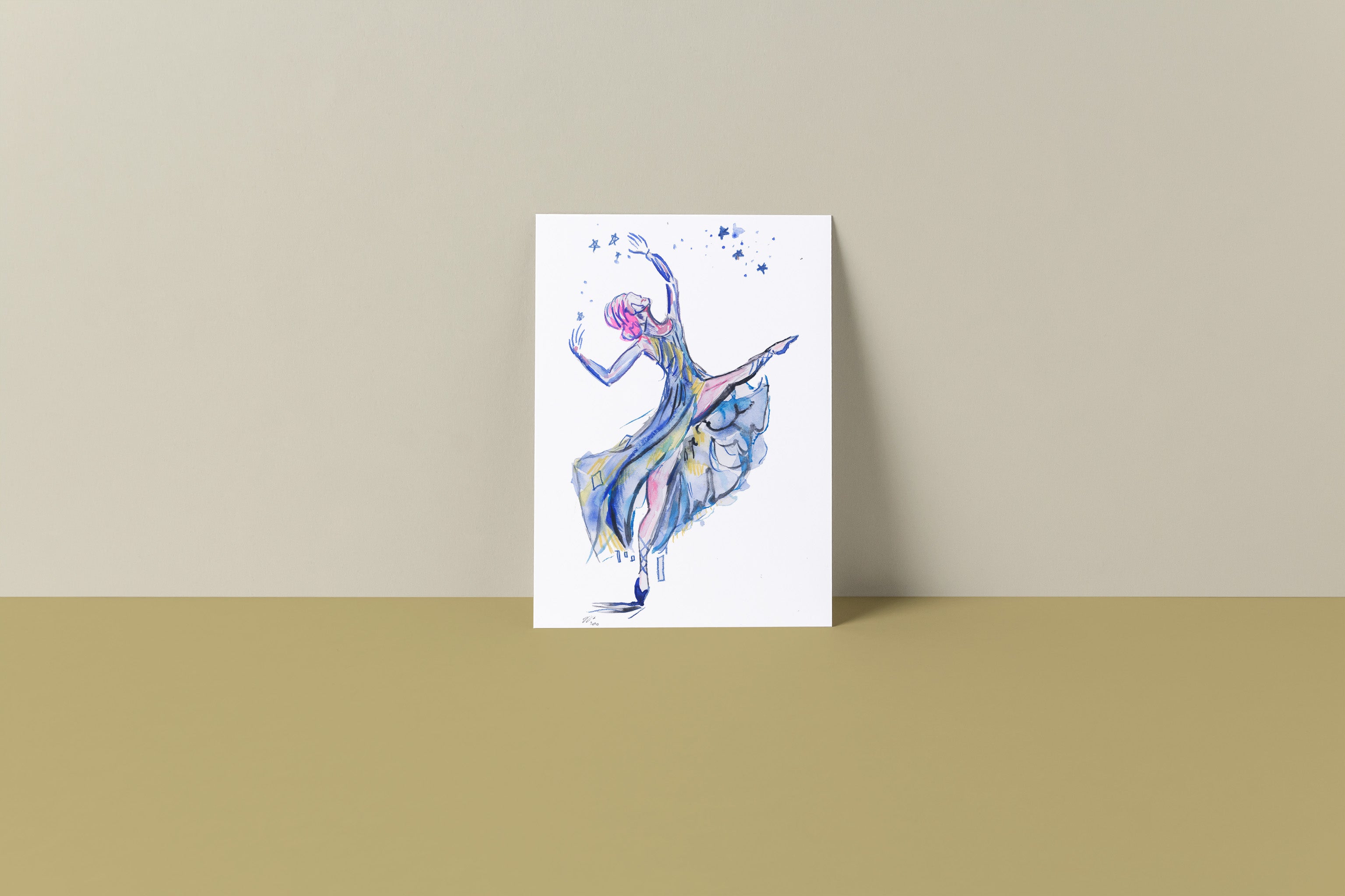 Mockup image of a 6 by 9 inch art print of a ballerina. She is wearing a blue gown with her arms in the air reaching towards the stars